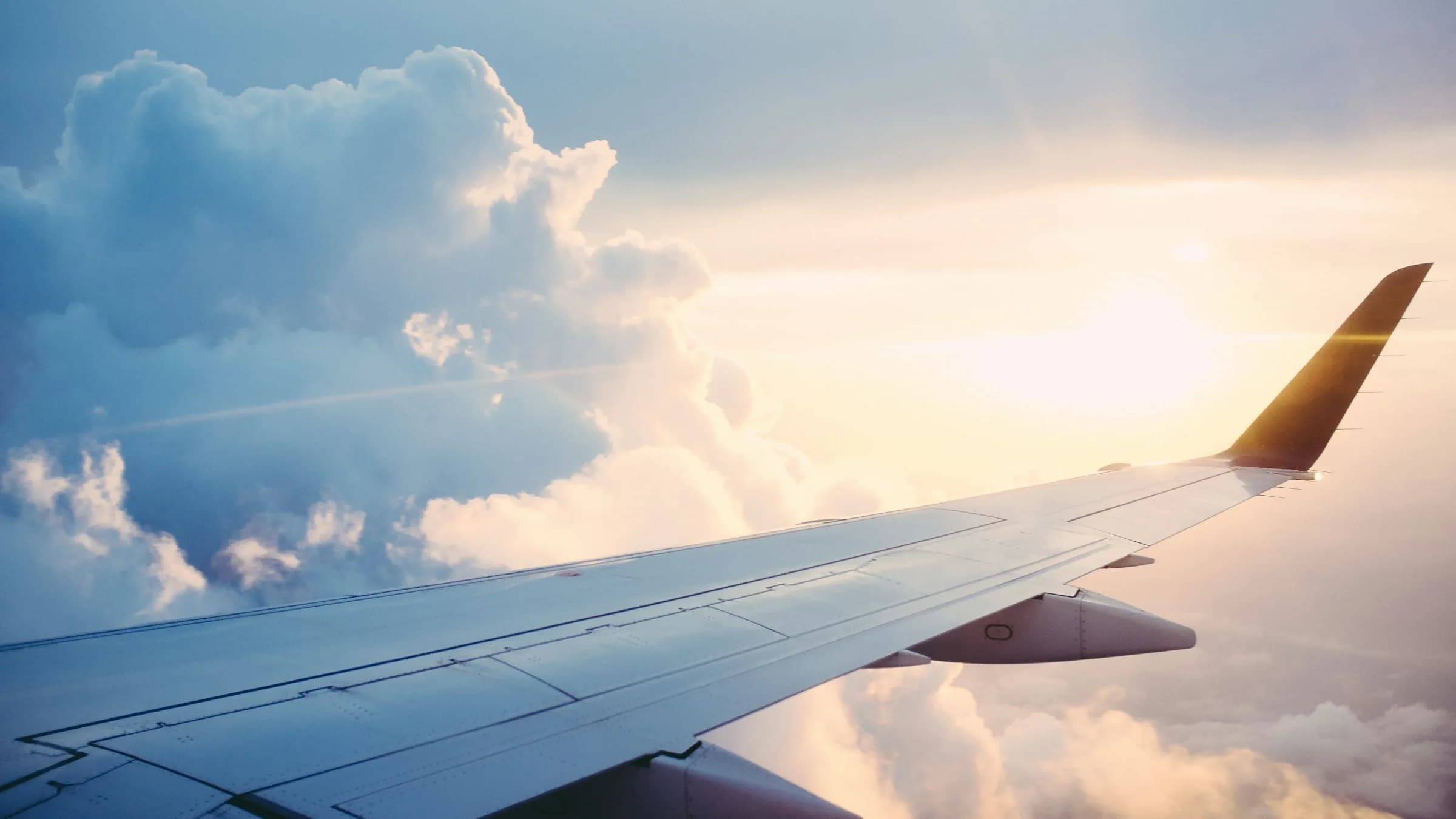 Airplane wing above clouds — start the passport pathways ranking